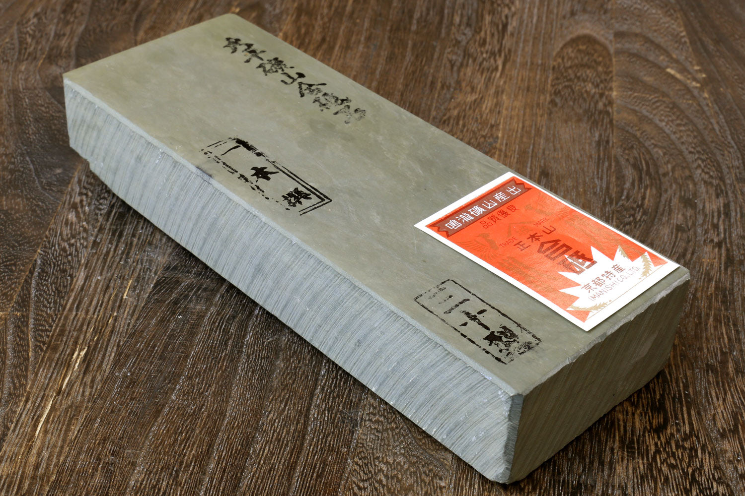 Natural sharpening whetstone with printed markings and orange label on top