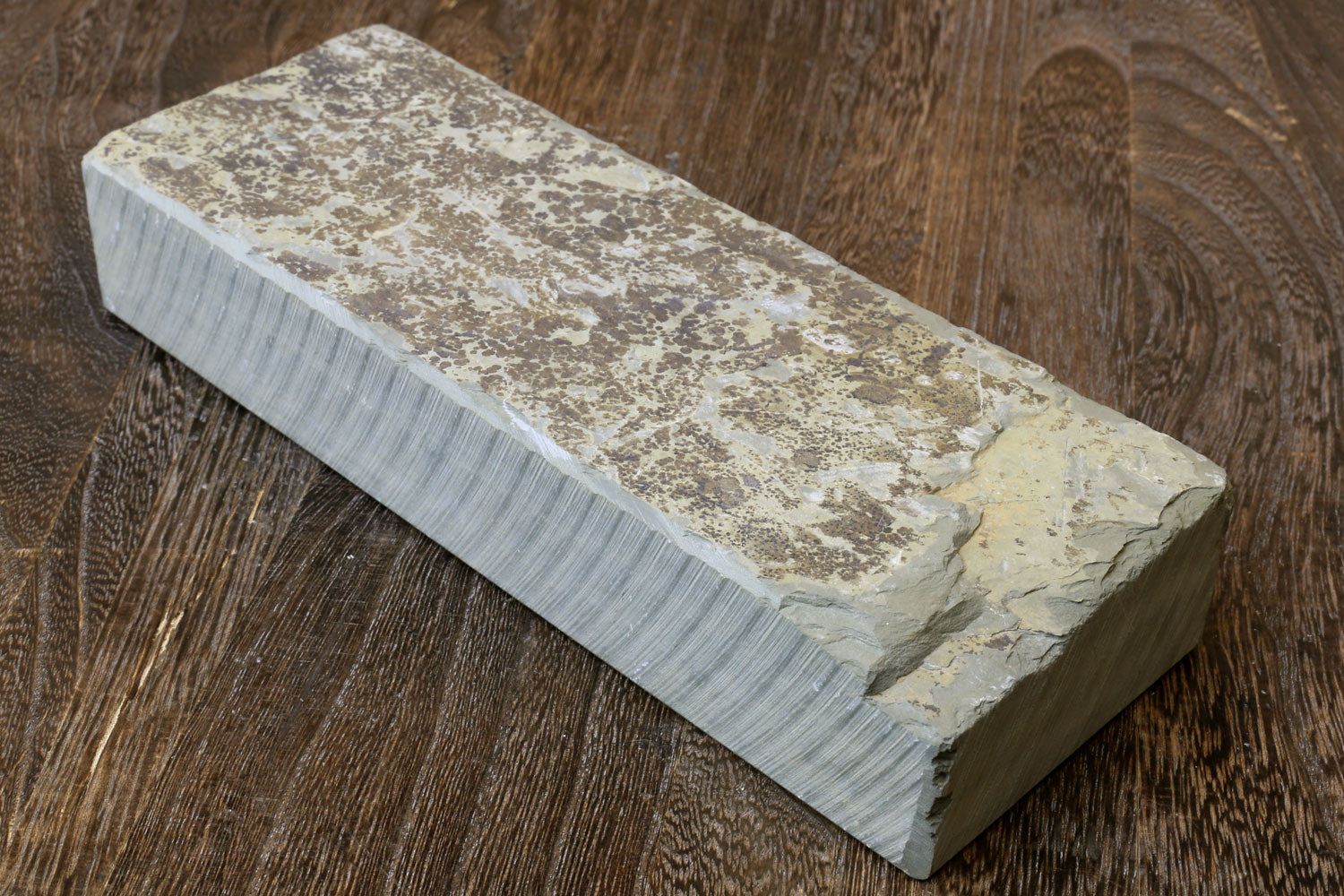 Natural sharpening whetstone block with speckled light and dark stone surface