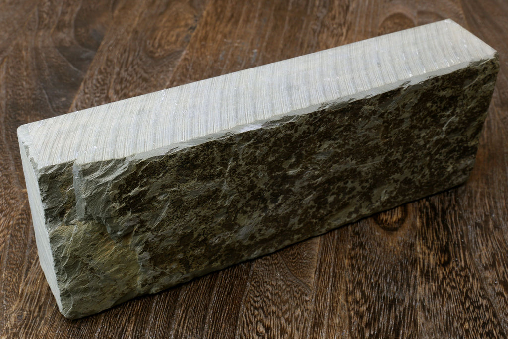 Natural sharpening whetstone block with dark green surface and pale sides