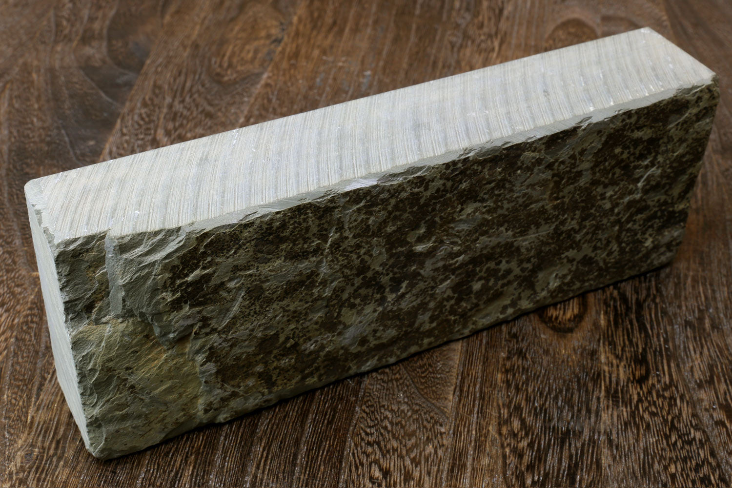 Natural sharpening whetstone block with dark green surface and pale sides