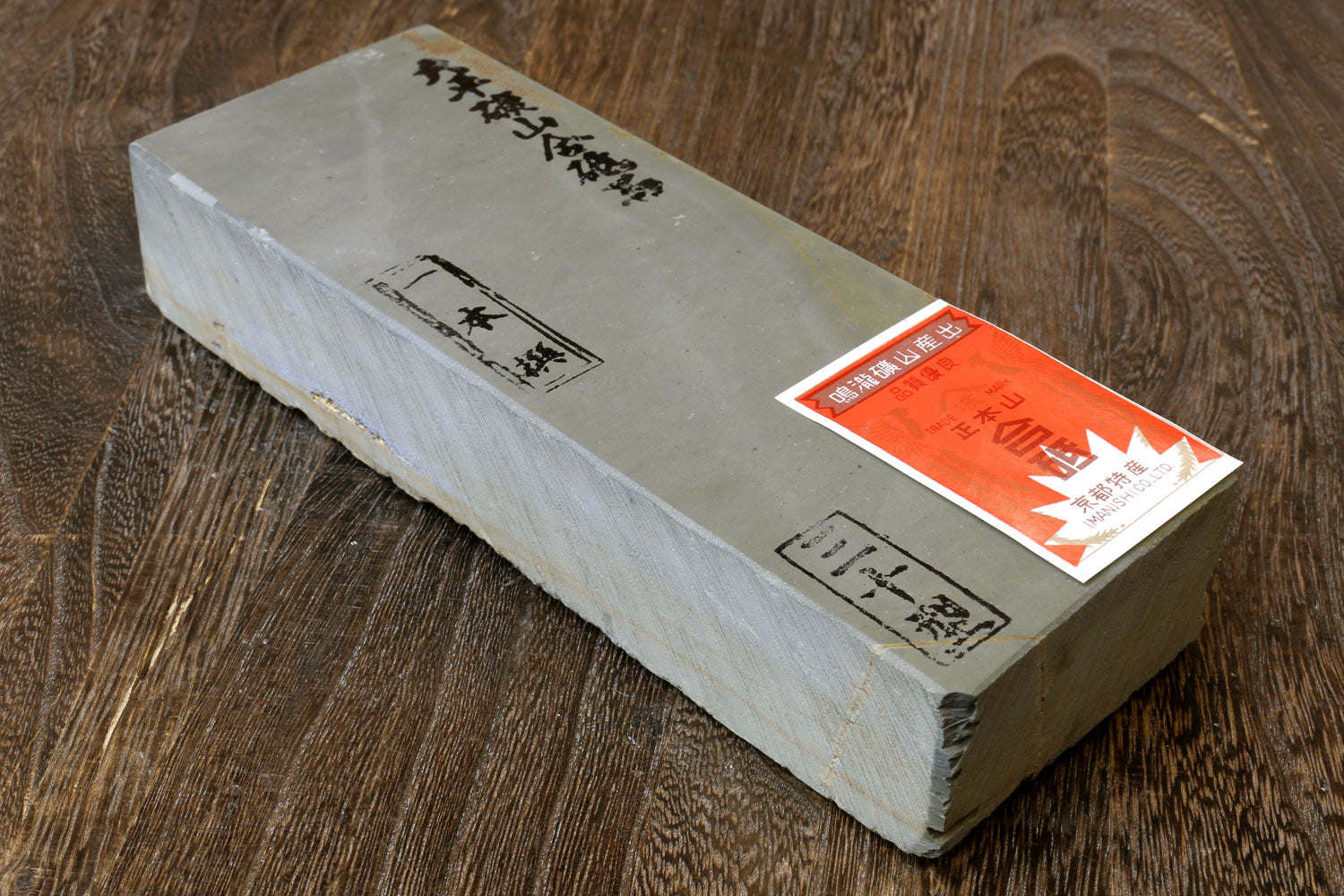 Natural whetstone block with pale surface and printed label with red sticker