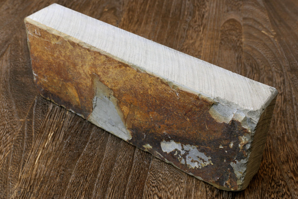 Whetstone sharpening stone, rectangular block with mottled brown surface and white patches