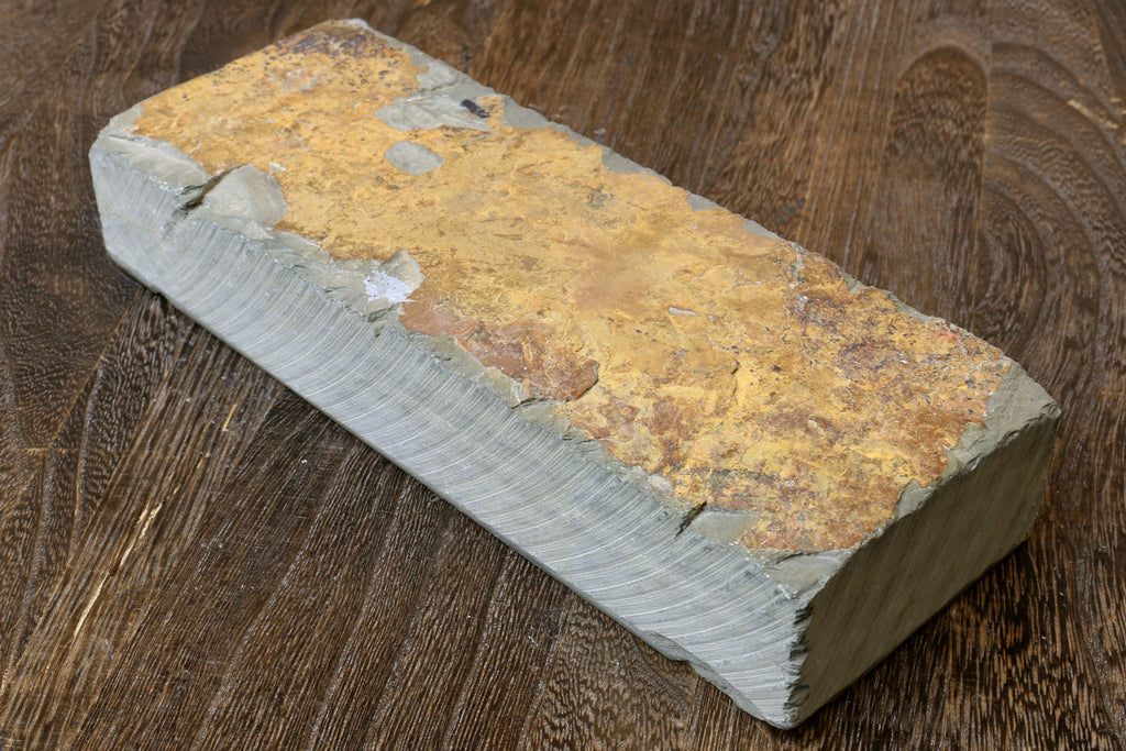 Natural whetstone block, yellow-brown stone with white side and rough edges.