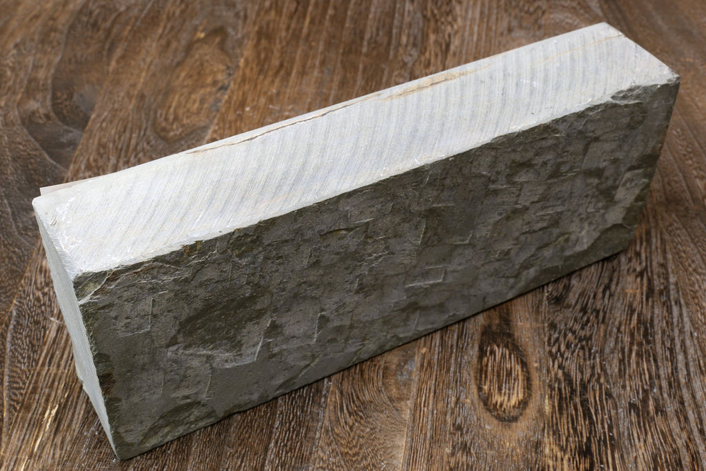 Natural sharpening whetstone block, dark gray side with textured surface