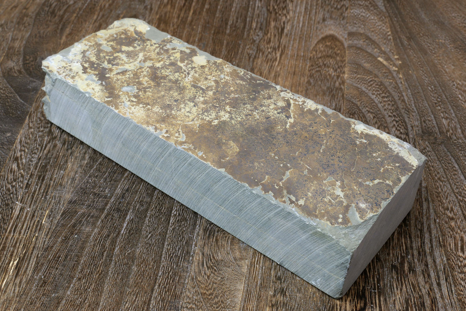 Natural sharpening whetstone, rectangular block with speckled brown-gray surface and pale edges