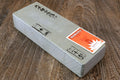 Natural whetstone block with printed text and orange-and-red label on the side