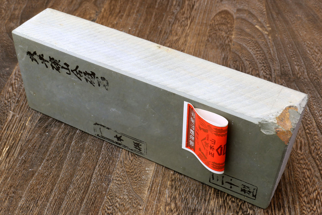 Natural whetstone block with side text and small red label on the end face