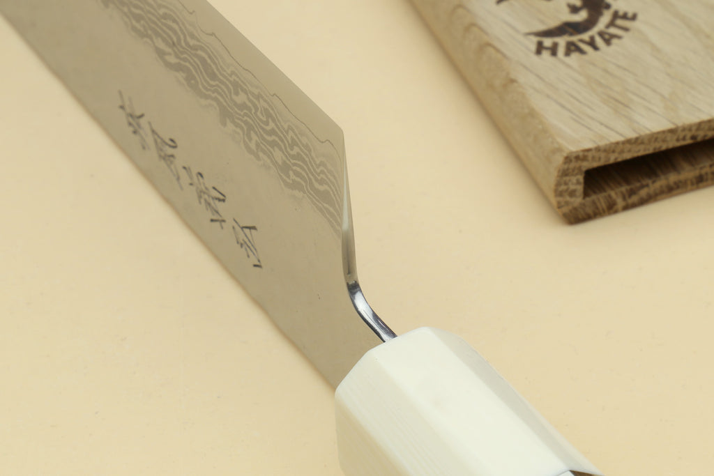Japanese chef’s gyuto knife close-up of Damascus blade and white handle