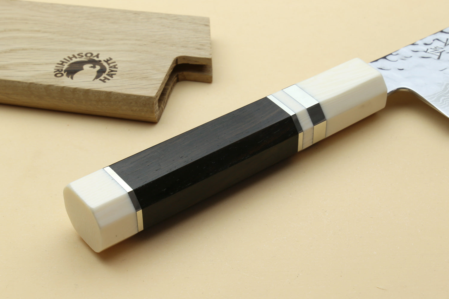 Japanese chef’s gyuto knife handle detail with white scales and dark grip