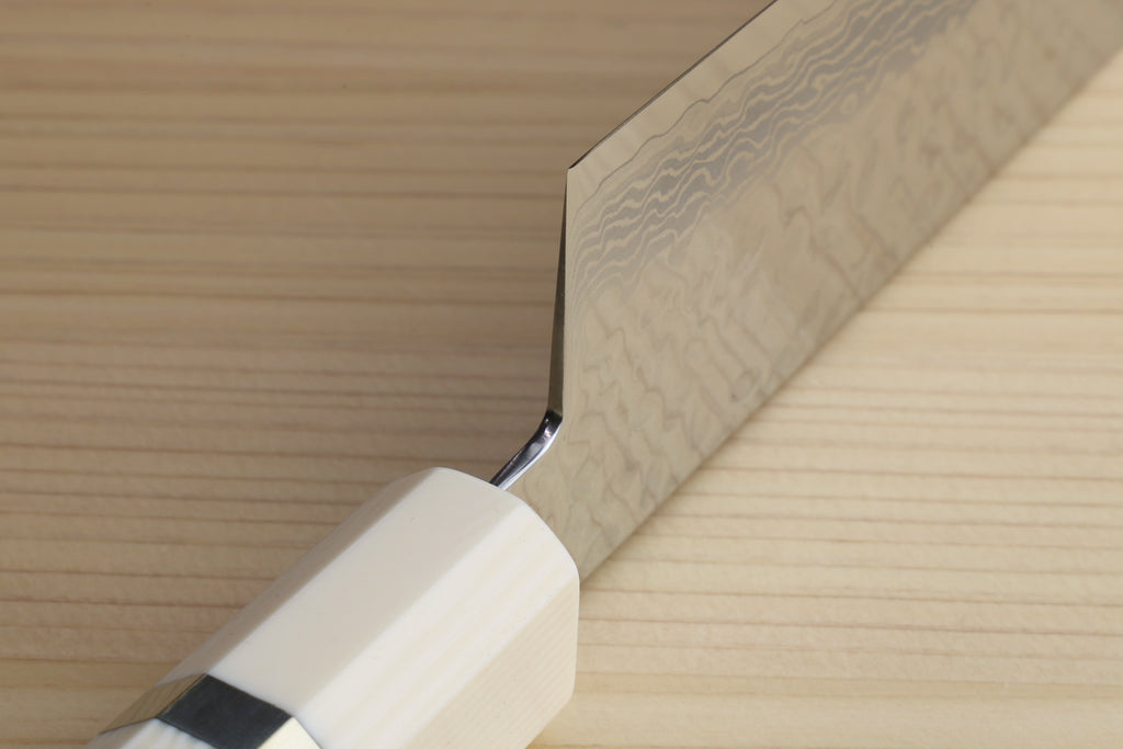 Nakiri vegetable knife close-up of ivory bolster and hammered Damascus blade