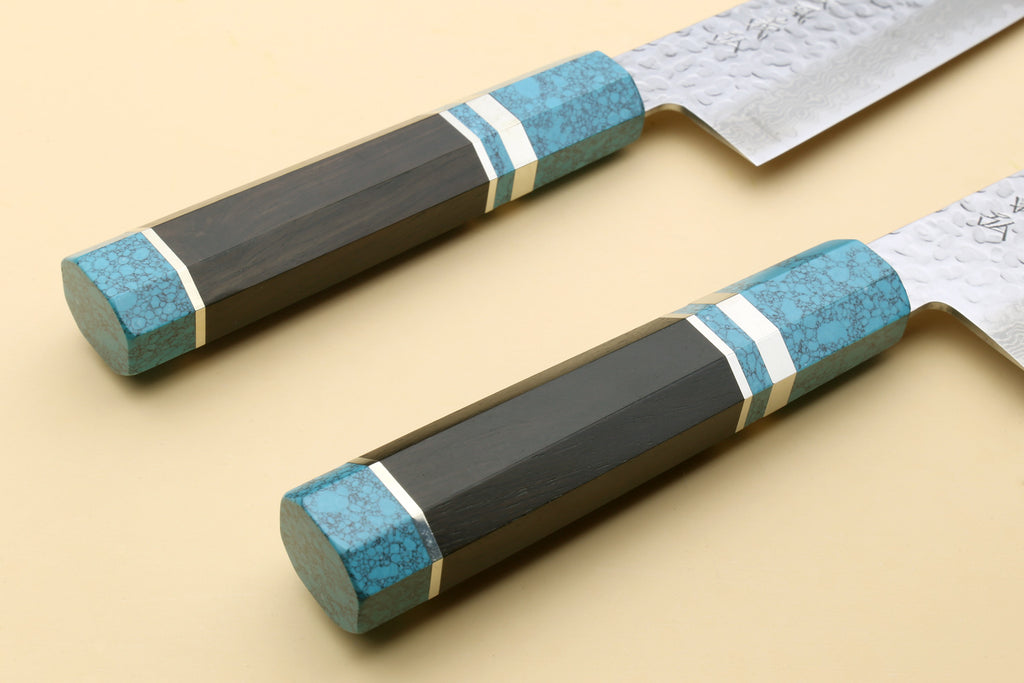 Two chef's gyuto knives with turquoise blue octagonal handles and hammered Damascus blades