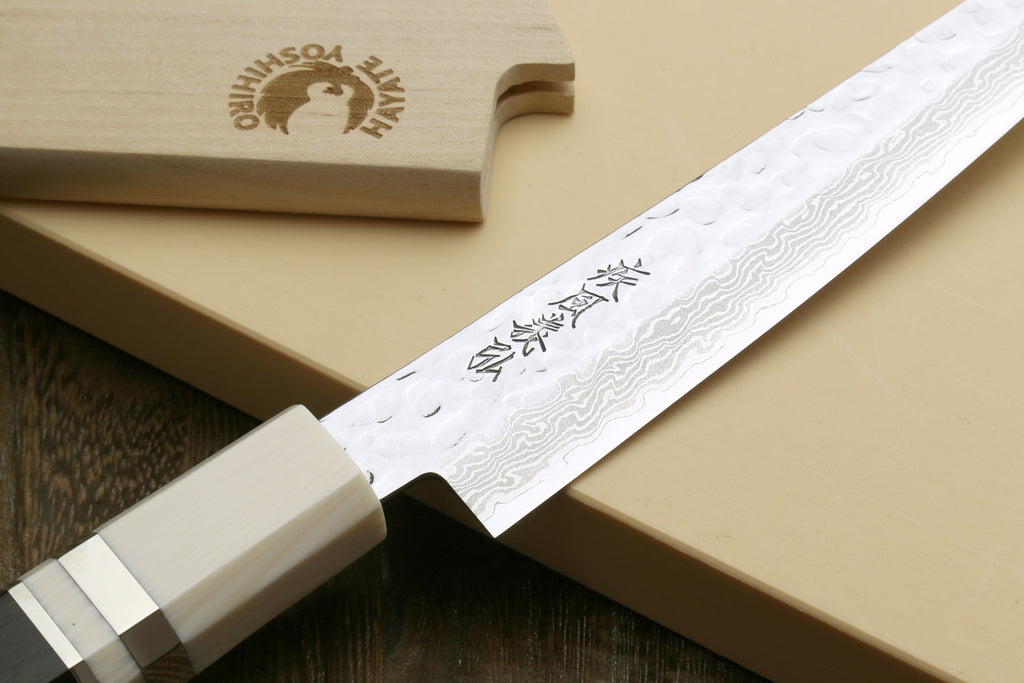 Damascus petty knife showing blade etching and ivory handle with black spacer