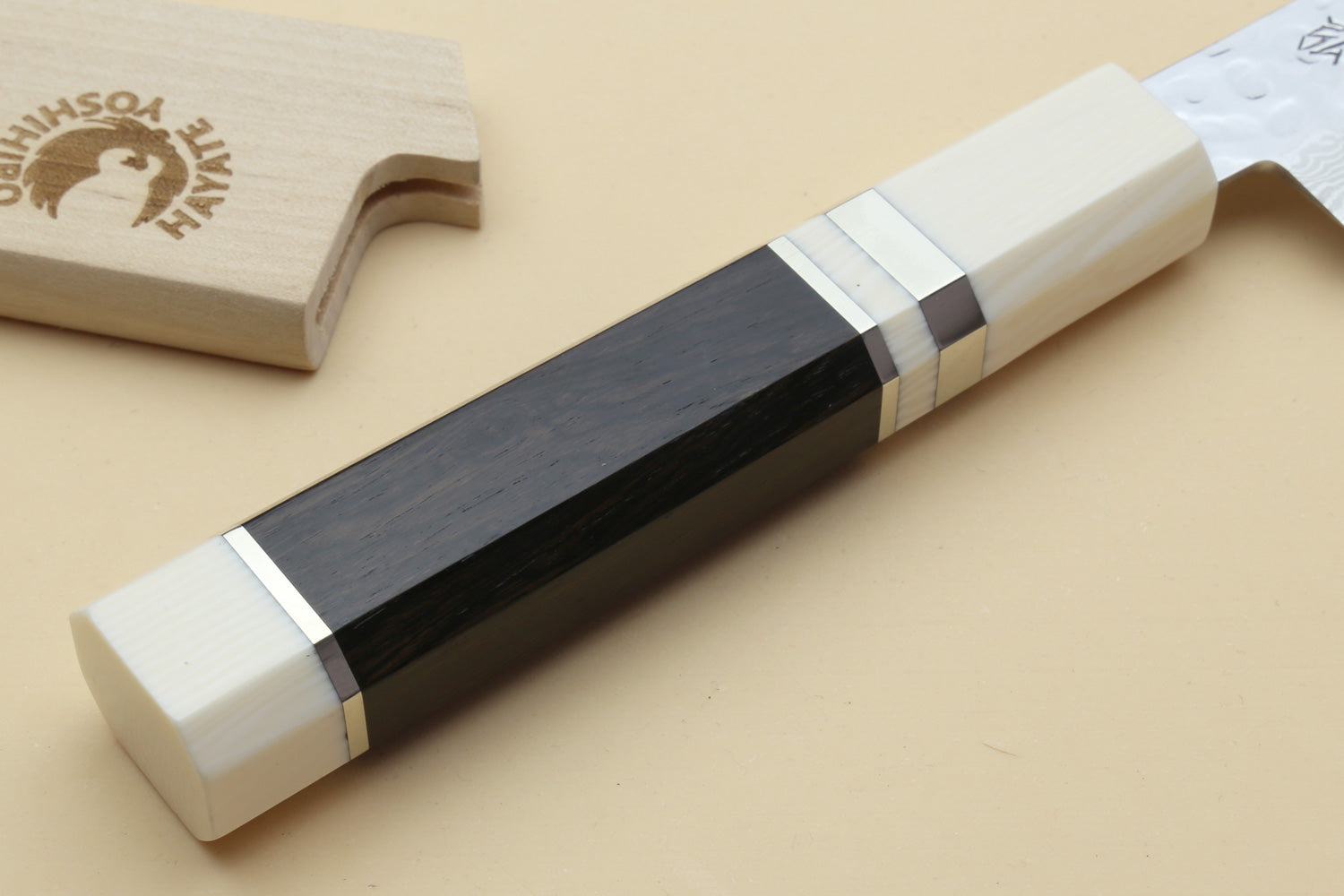 Damascus petty knife handle end with ivory scales and dark center spine