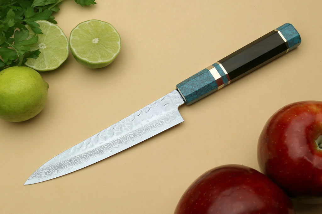Petty utility chef knife shown in profile, with Damascus blade and blue handle.