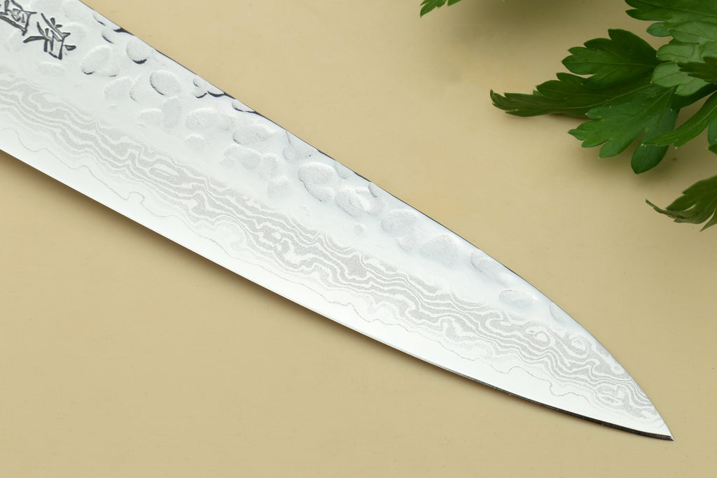 Damascus petty utility knife blade with hammered texture and pointed tip.