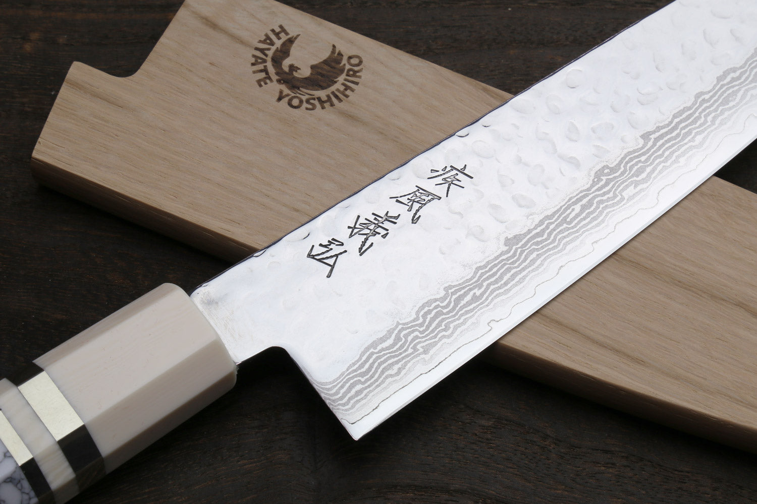 Damascus santoku knife with stamped blade markings, white howlite handle and wooden saya