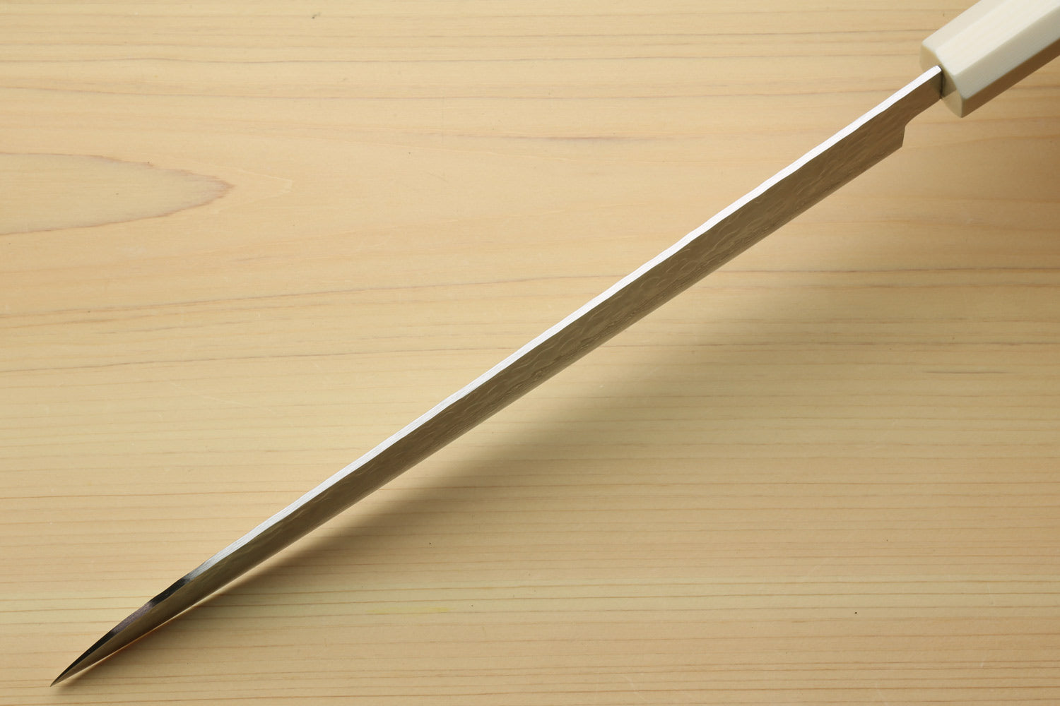 Japanese sujihiki slicer knife tip and spine with damascus blade and ivory-toned handle