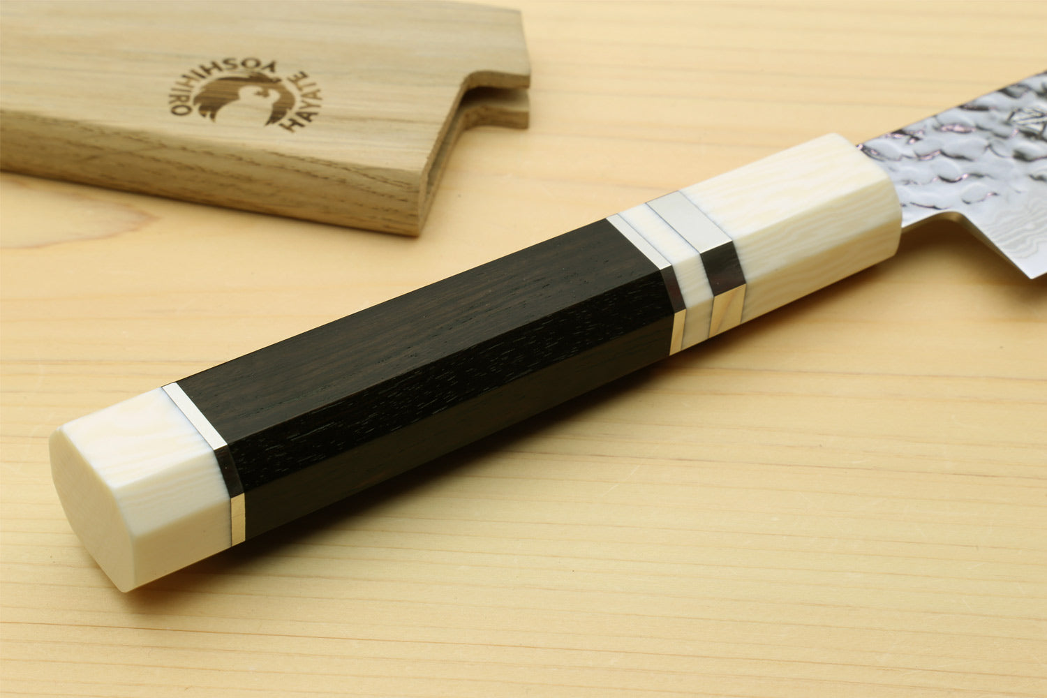 Japanese sujihiki slicer knife handle detail: ivory-toned and black grip with metal bands