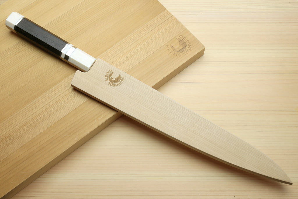 Japanese sujihiki slicer knife with damascus blade and dark grip handle, ivory-toned end