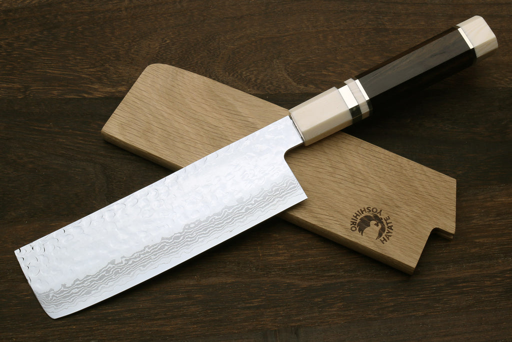 Nakiri vegetable knife with white damascus blade, dark handle, and light wooden saya sheath