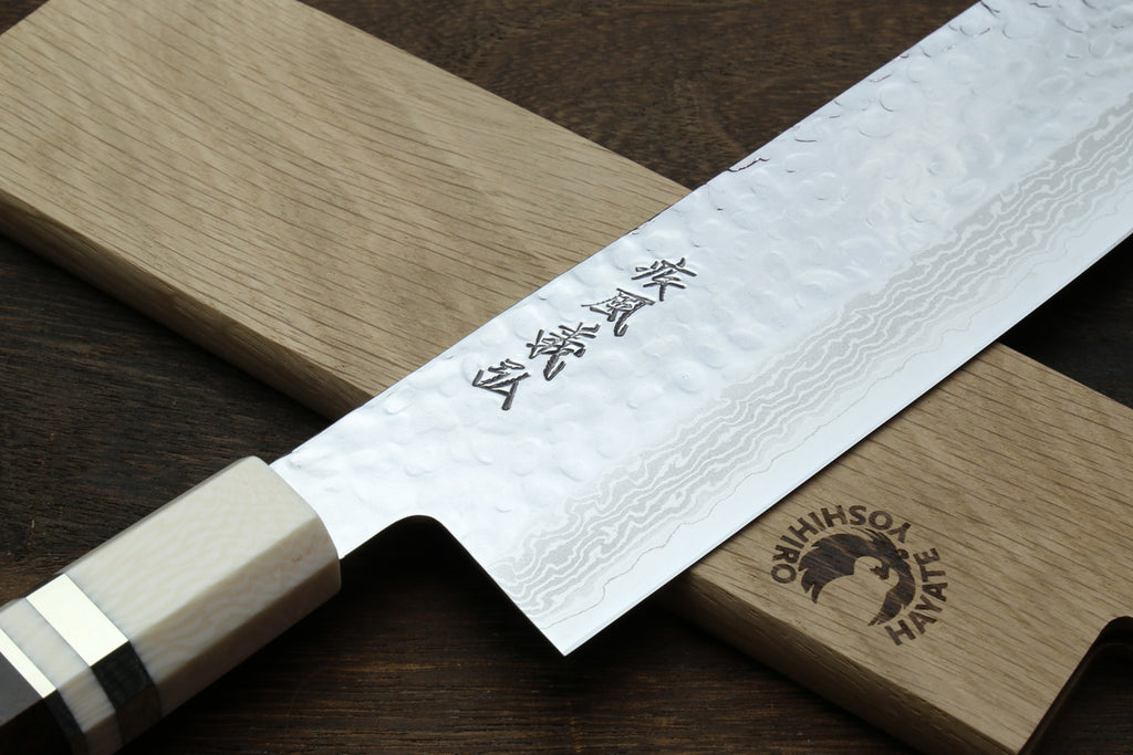 Nakiri knife close-up of white damascus blade and dark handle with ivory bolster