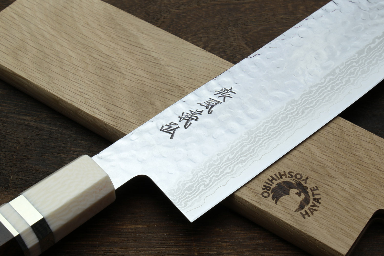 Nakiri knife close-up of white damascus blade and dark handle with ivory bolster