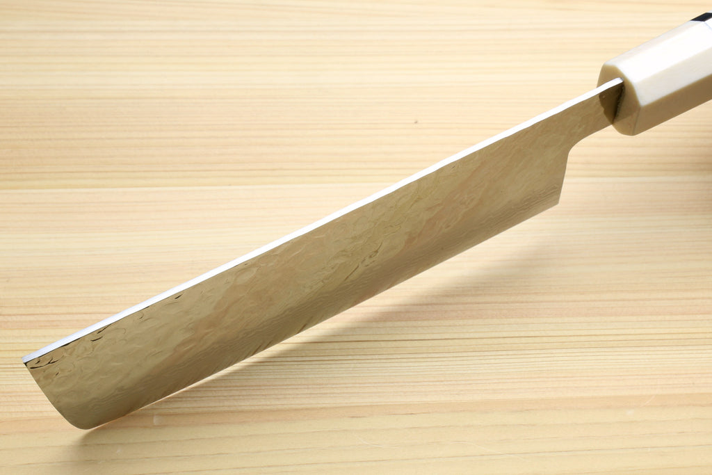 Nakiri knife back view with white damascus blade and dark handle on wooden board