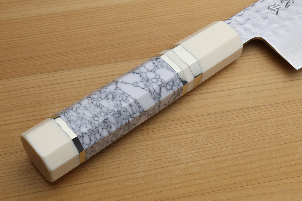 White howlite handle with gray veining on hammered Damascus nakiri blade