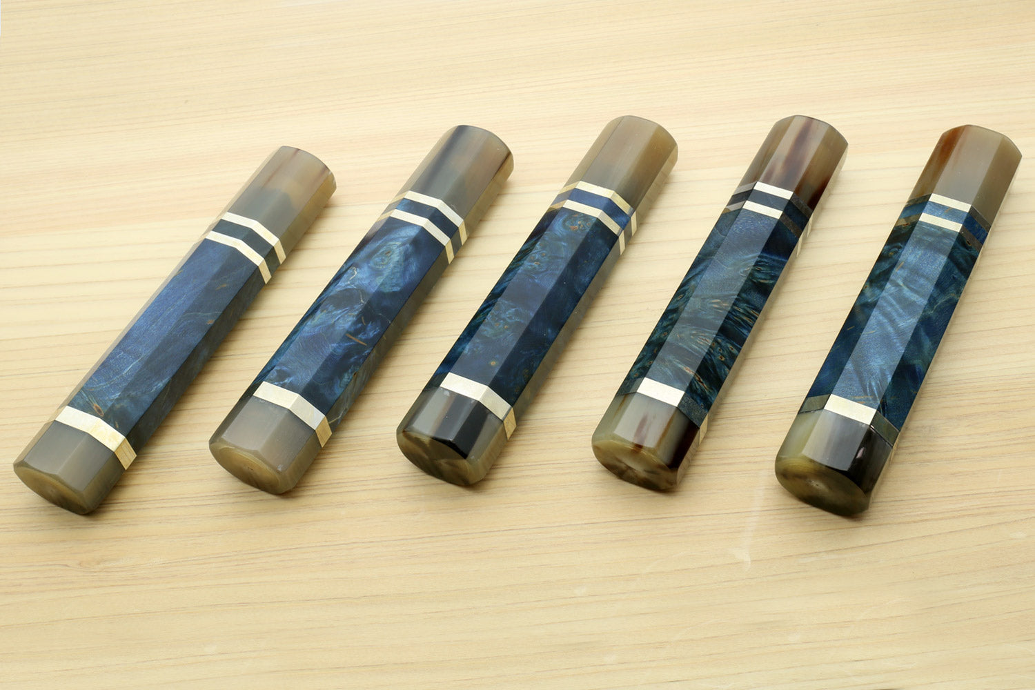 Five ocean blue knife handles with horn bolsters and striped rings