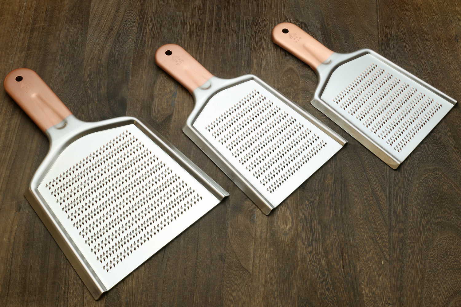 Stainless steel radish grater with copper-toned handle and perforated shredding surface