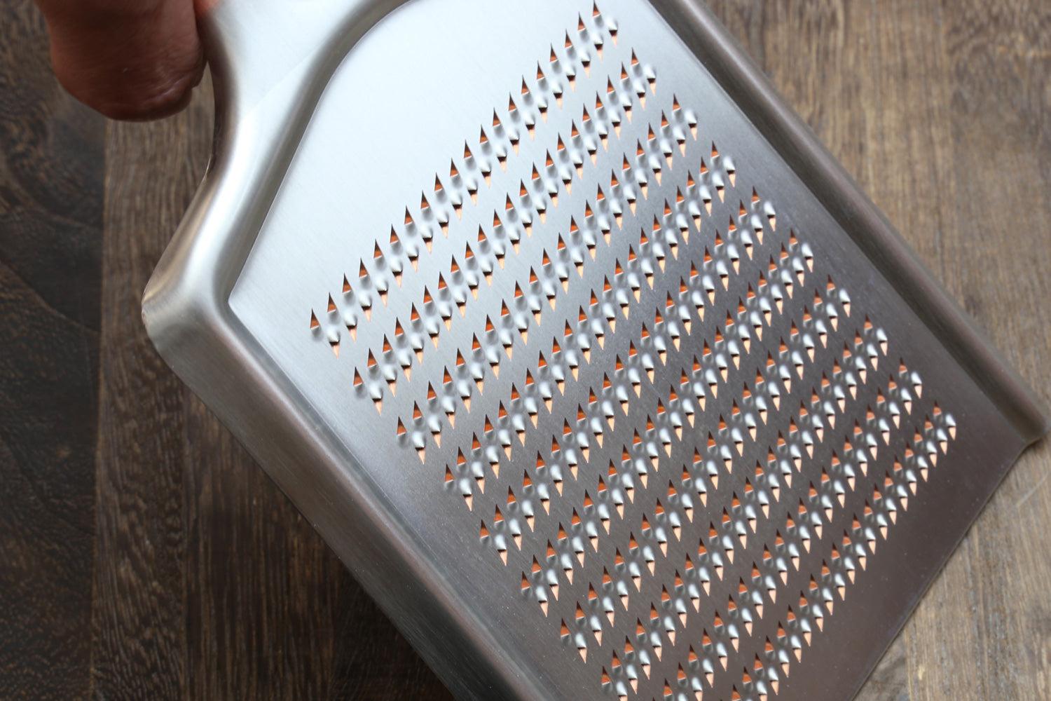 Radish grater showing perforated metal shredding pattern