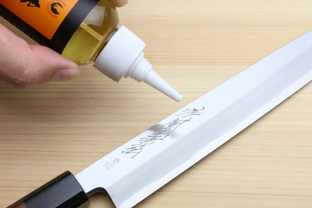 Knife oil care kit nozzle applying oil to a steel blade