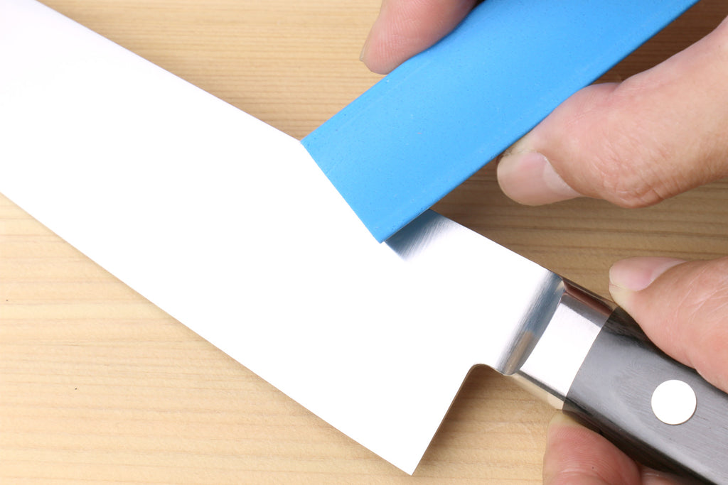 Rust eraser polishing a knife blade with a blue block