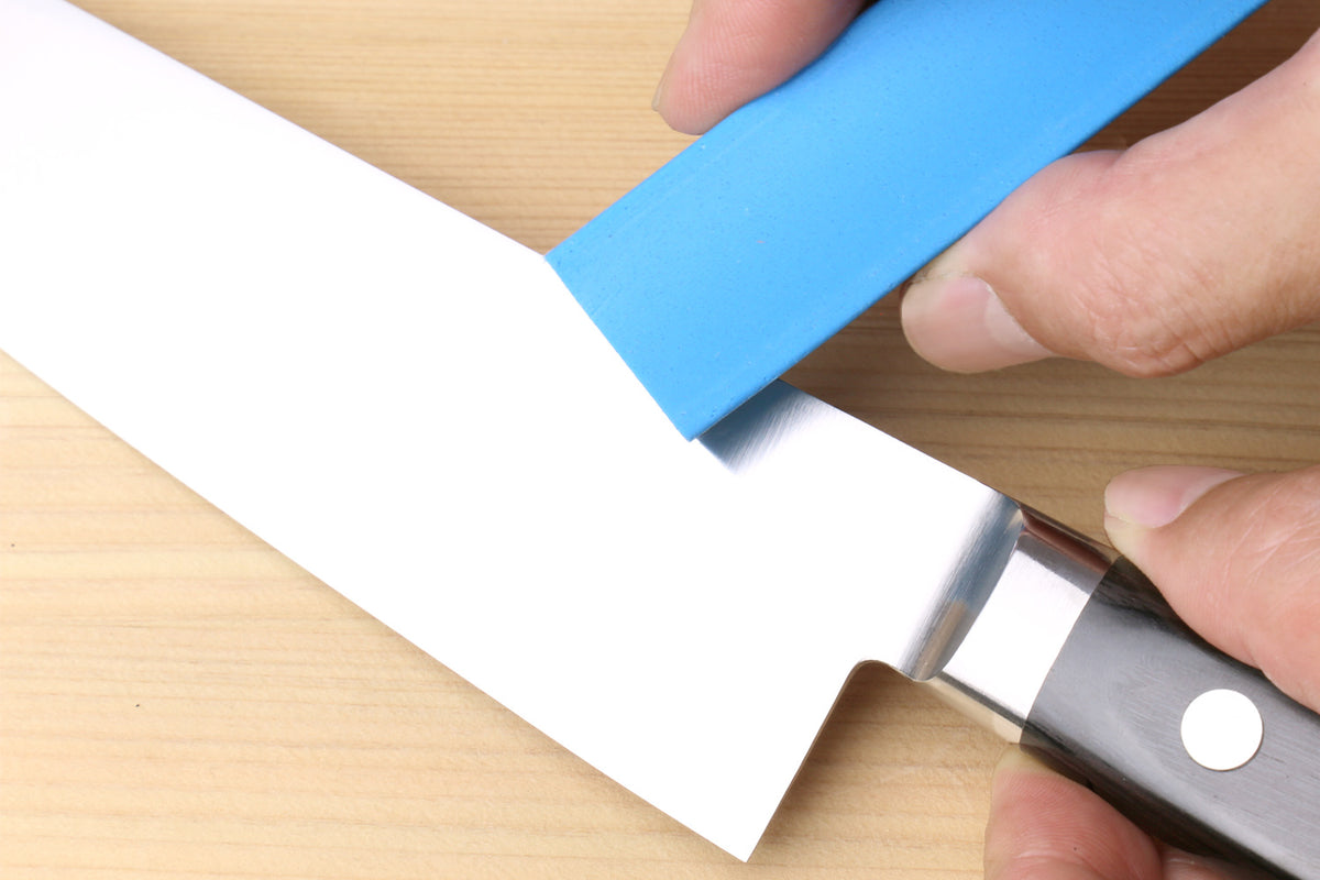 Rust eraser polishing a knife blade with a blue block