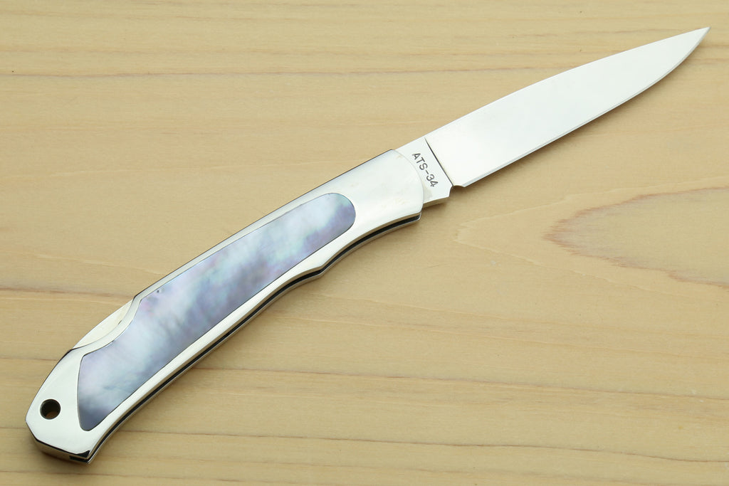 Stainless steel lockback folding pocket knife, open, white handle with abalone inlay
