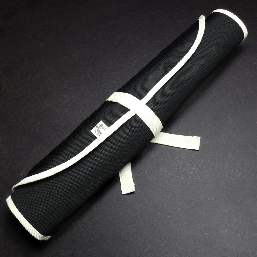 Rolled black cotton knife pouch with white wrap ties and small logo patch