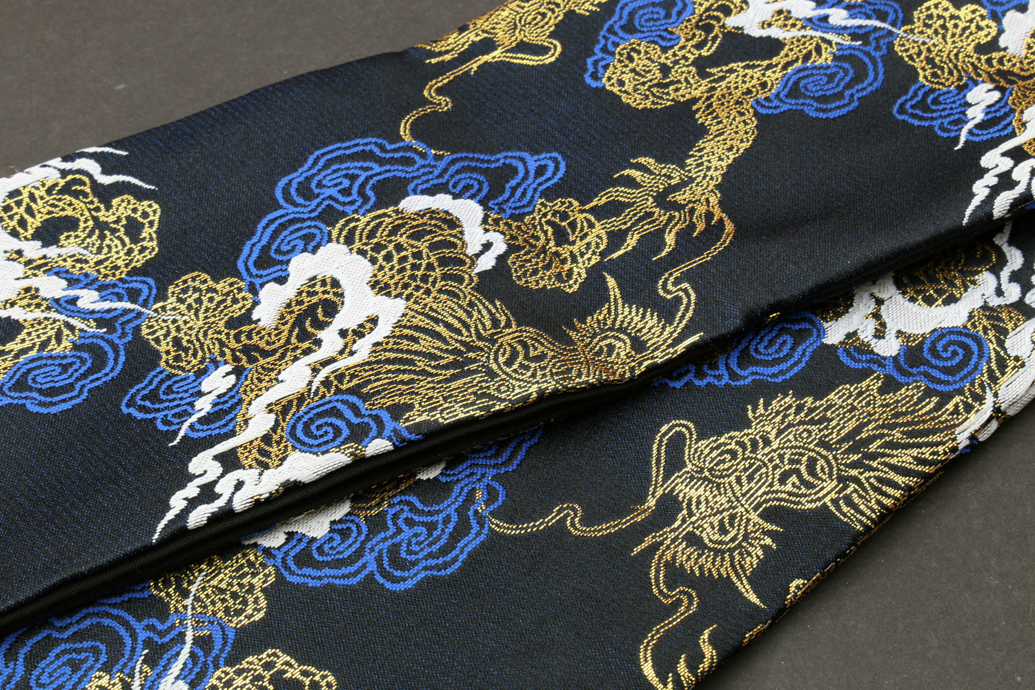 Black dragon-pattern knife pouch bag close-up with gold, blue and white embroidered dragons