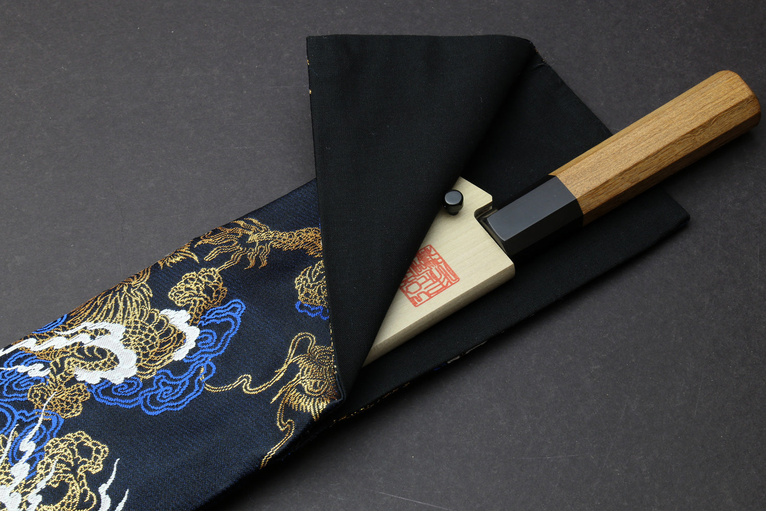 Black knife pouch bag with gold and blue dragon pattern, folded with snap closure flap