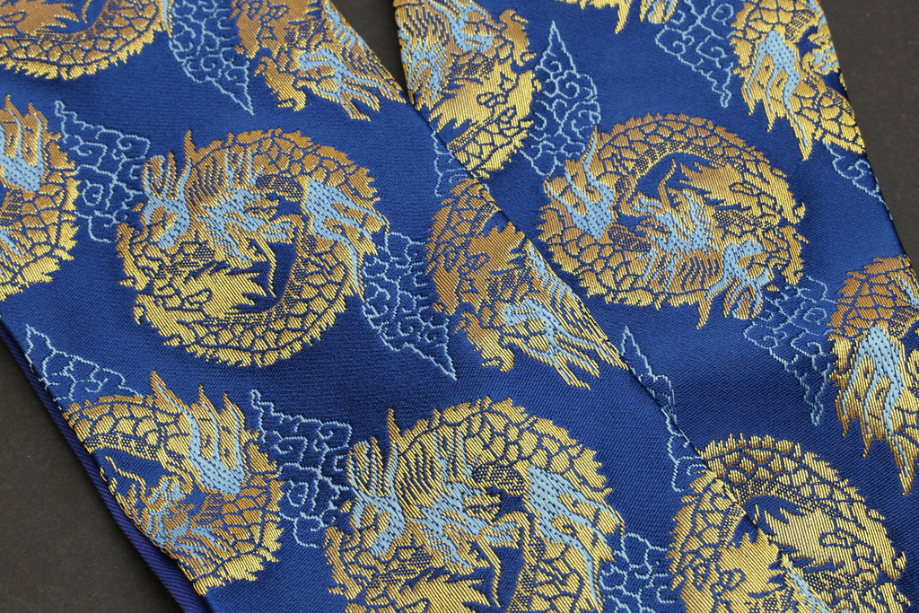 Blue fabric with repeating gold dragon medallion pattern, close-up on pouch