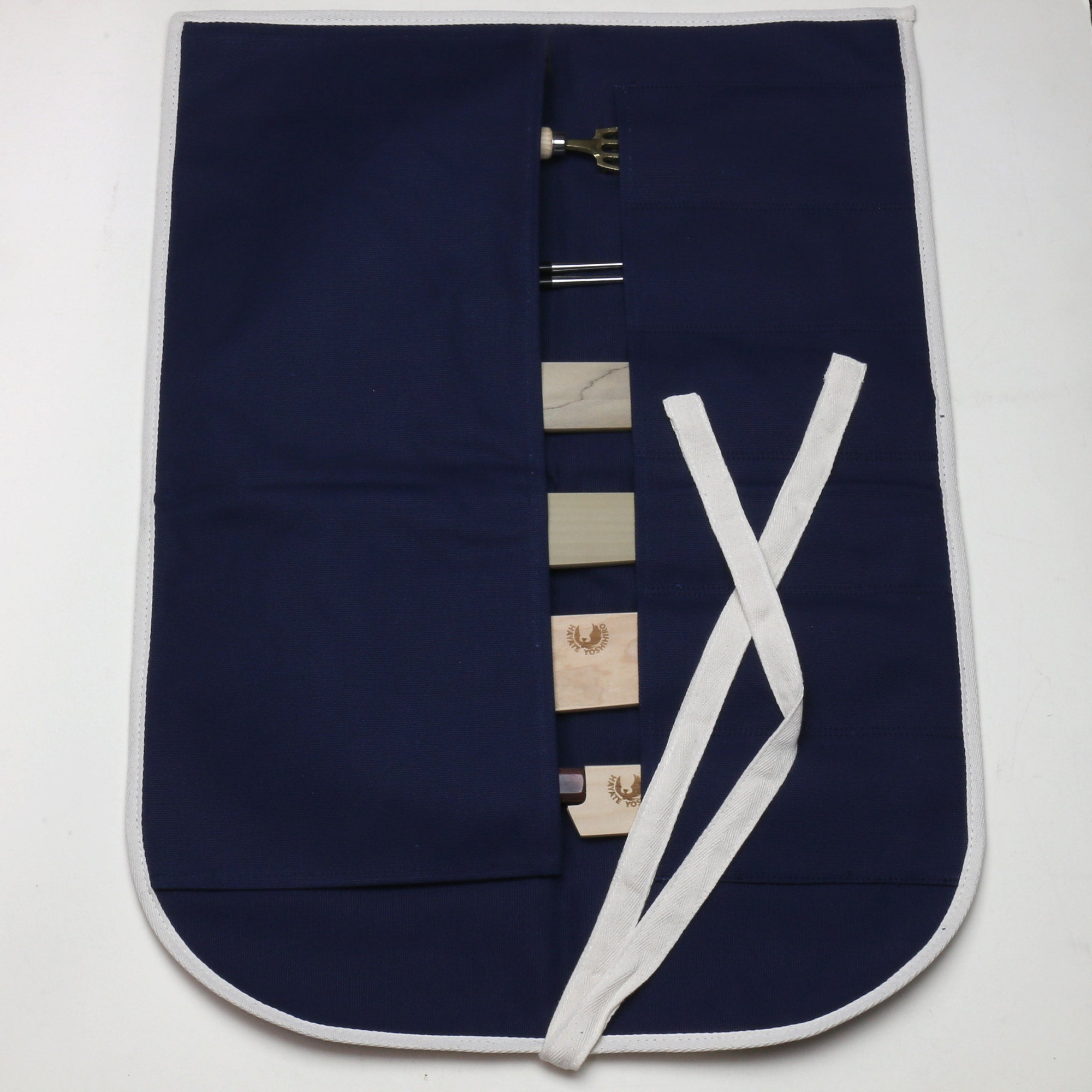 Dark navy cotton knife pouch bag open, showing six slot pockets and white tie closure