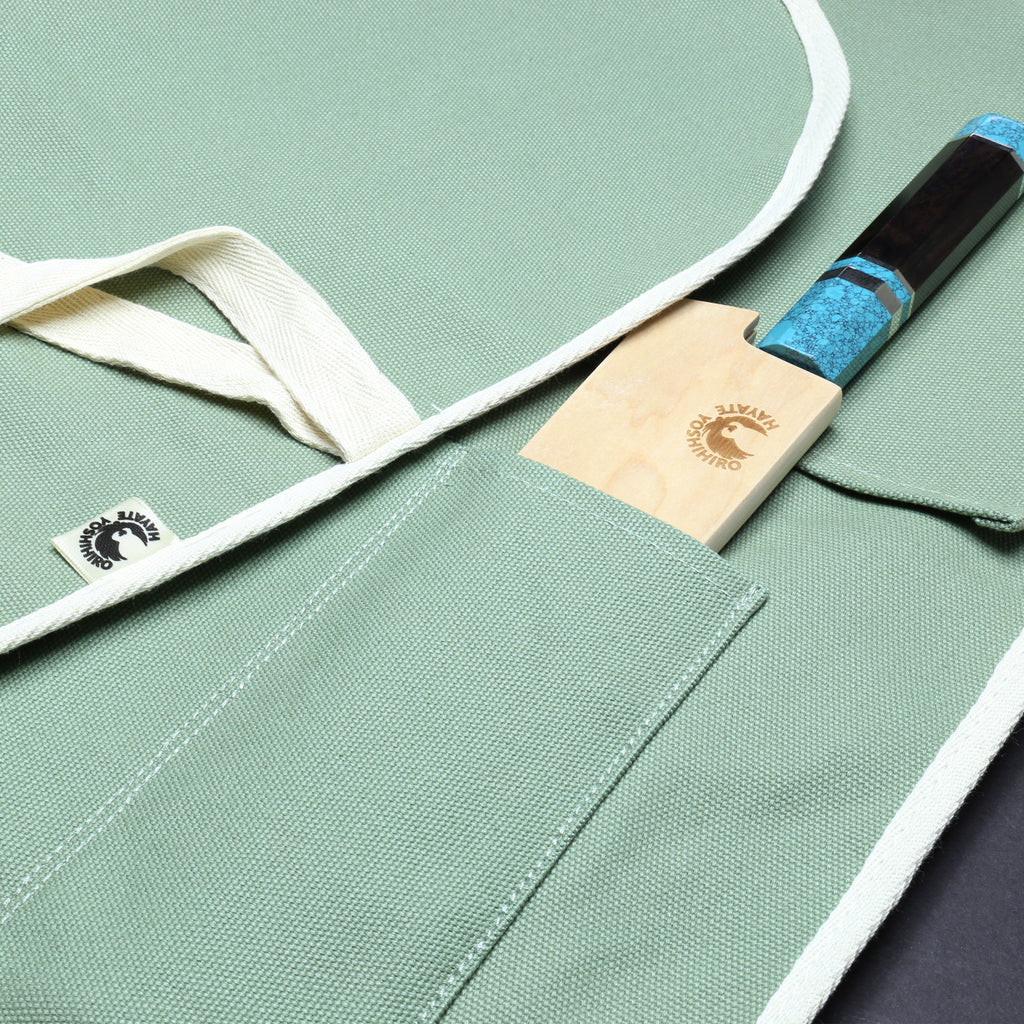 Olive-green cotton knife pouch bag detail with stitched pockets and logo patch