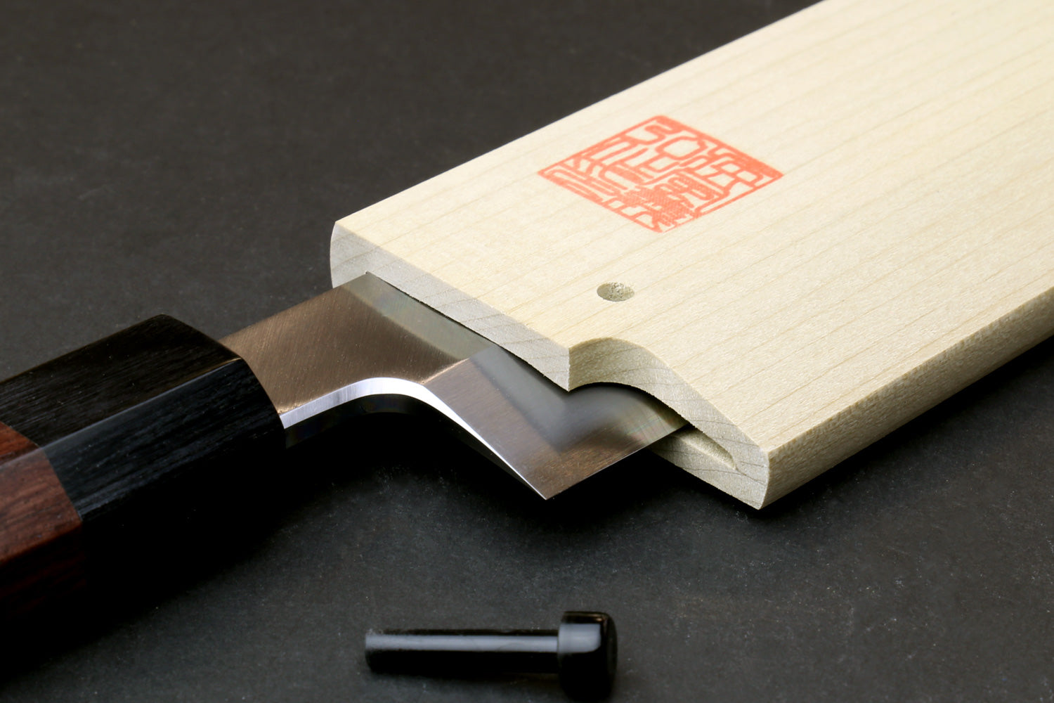 Wooden saya cover with open slot, red stamp label, pale natural magnolia