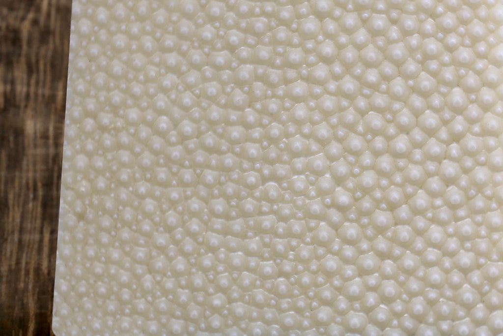 White sharkskin grating surface with small circular bumps