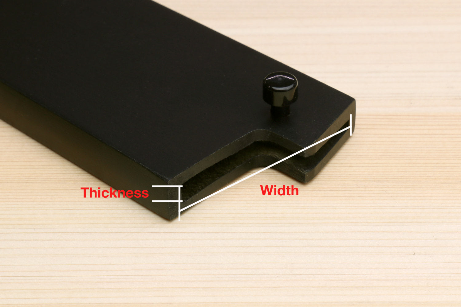 Santoku blade cover close-up with thickness and width measurement points on dark saya