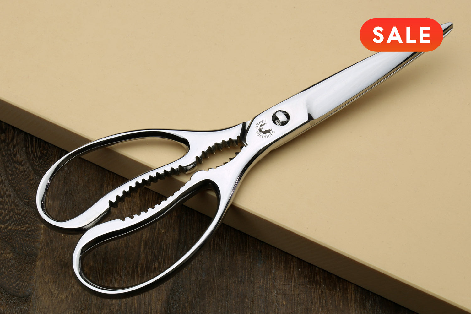 Large stainless kitchen shears with white handle, scalloped blade and finger loops