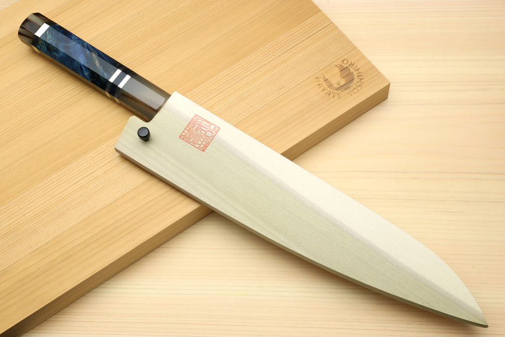 Chef knife with Damascus blade and ocean blue handle, angled view