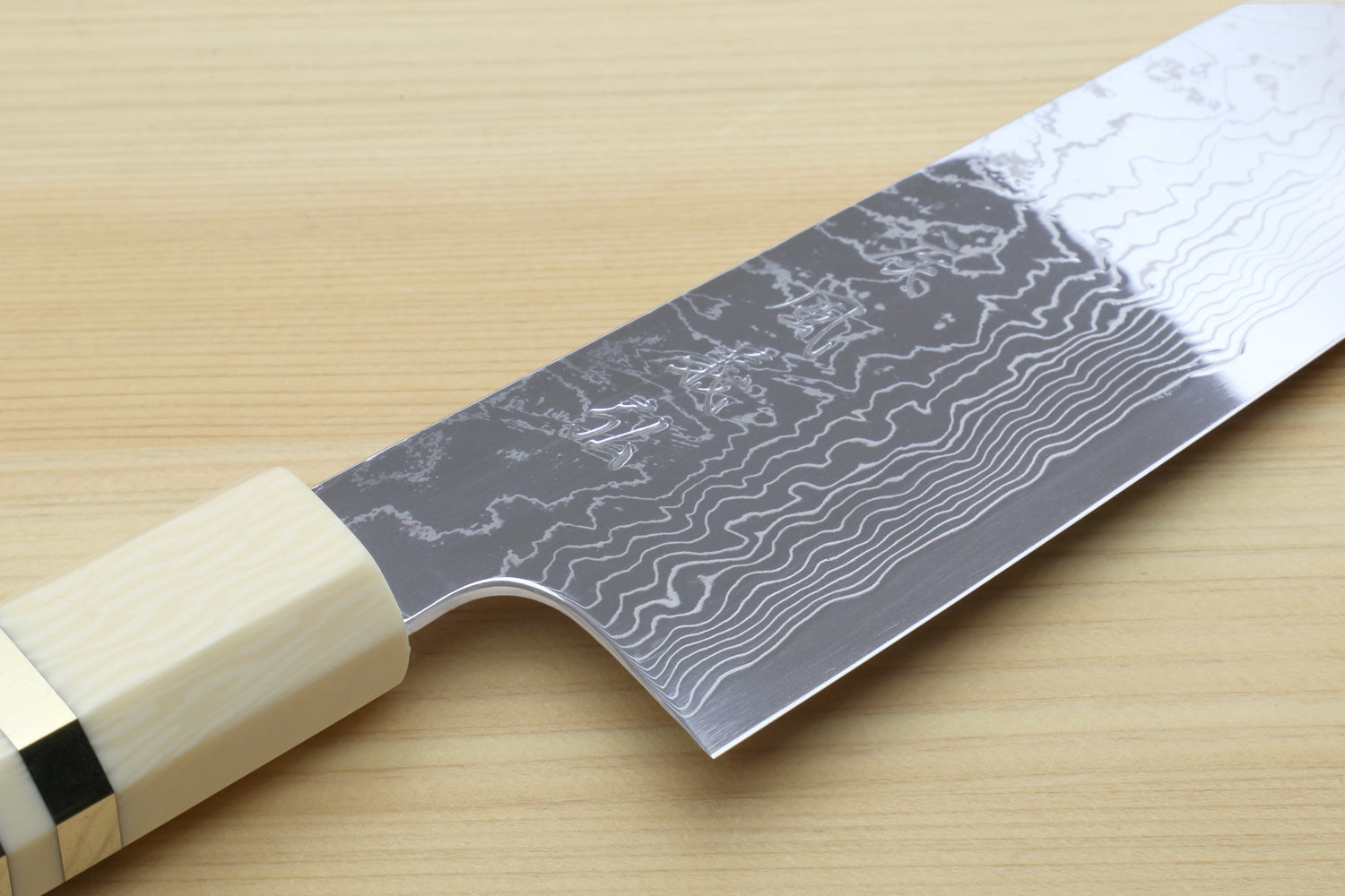 Damascus gyuto chef knife close view of patterned blade and ivory bolster