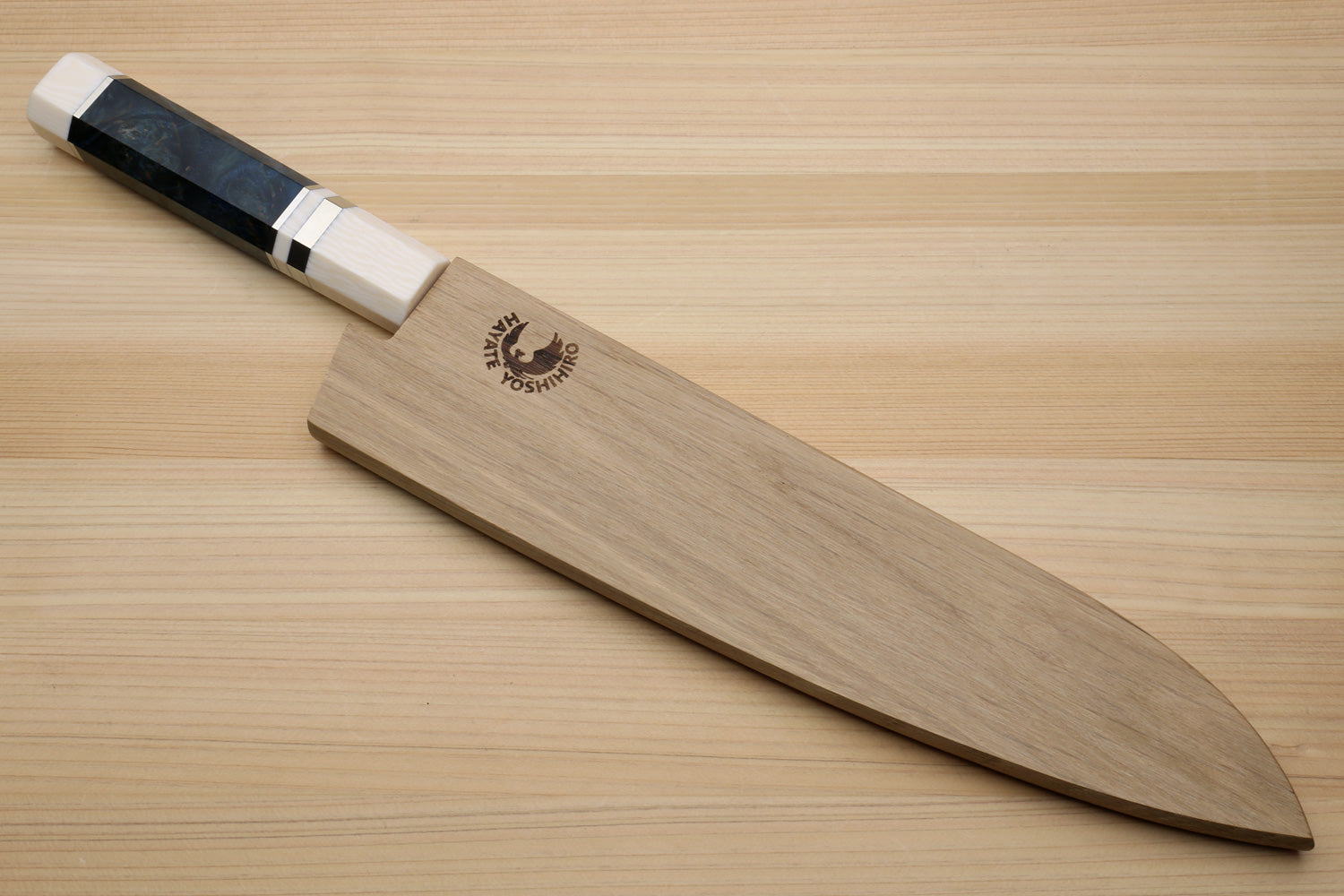 Damascus gyuto chef knife with ocean blue handle, ivory bolster, on wooden stand