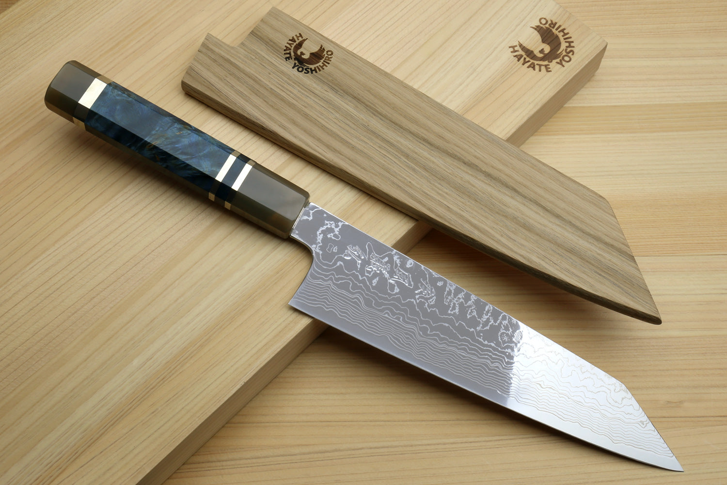 Kiritsuke chef knife with Damascus blade and ocean blue handle on wooden board