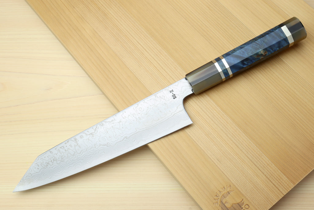 Kiritsuke chef knife with Damascus blade and ocean blue handle, side view on wood